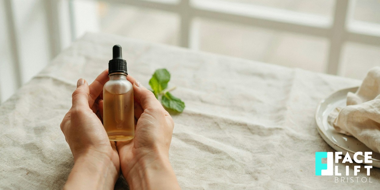 Close-up of a person’s hands cradling a small unbranded glass serum bottle in soft natural daylight, evoking calm, considered skincare